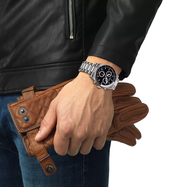 Hand wearing a silver watch with a brown leather wallet and glove, against a white background