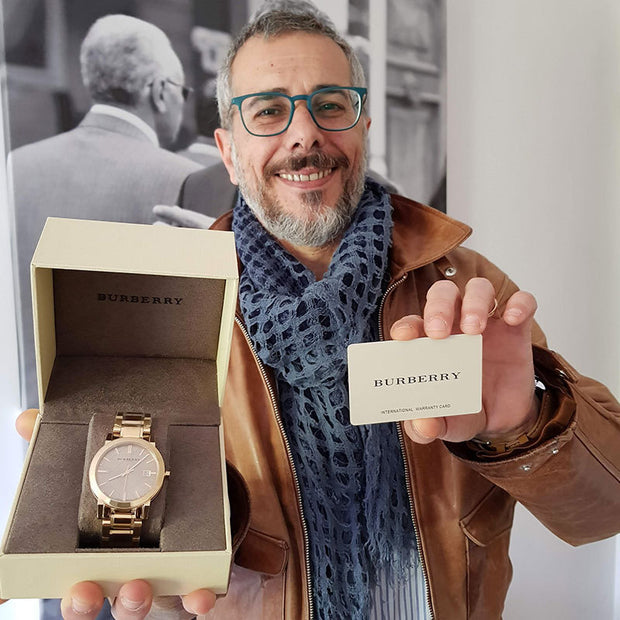 Man holding a Burberry watch and card